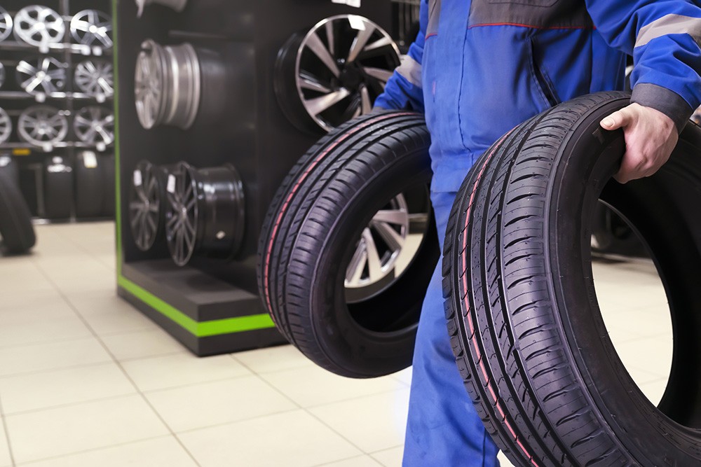 Choose tires that match your climate conditions Mechanic carrying vehicle tires. Photo ID 237320416 © Vladimir Razgulyaev | Dreamstime.com
